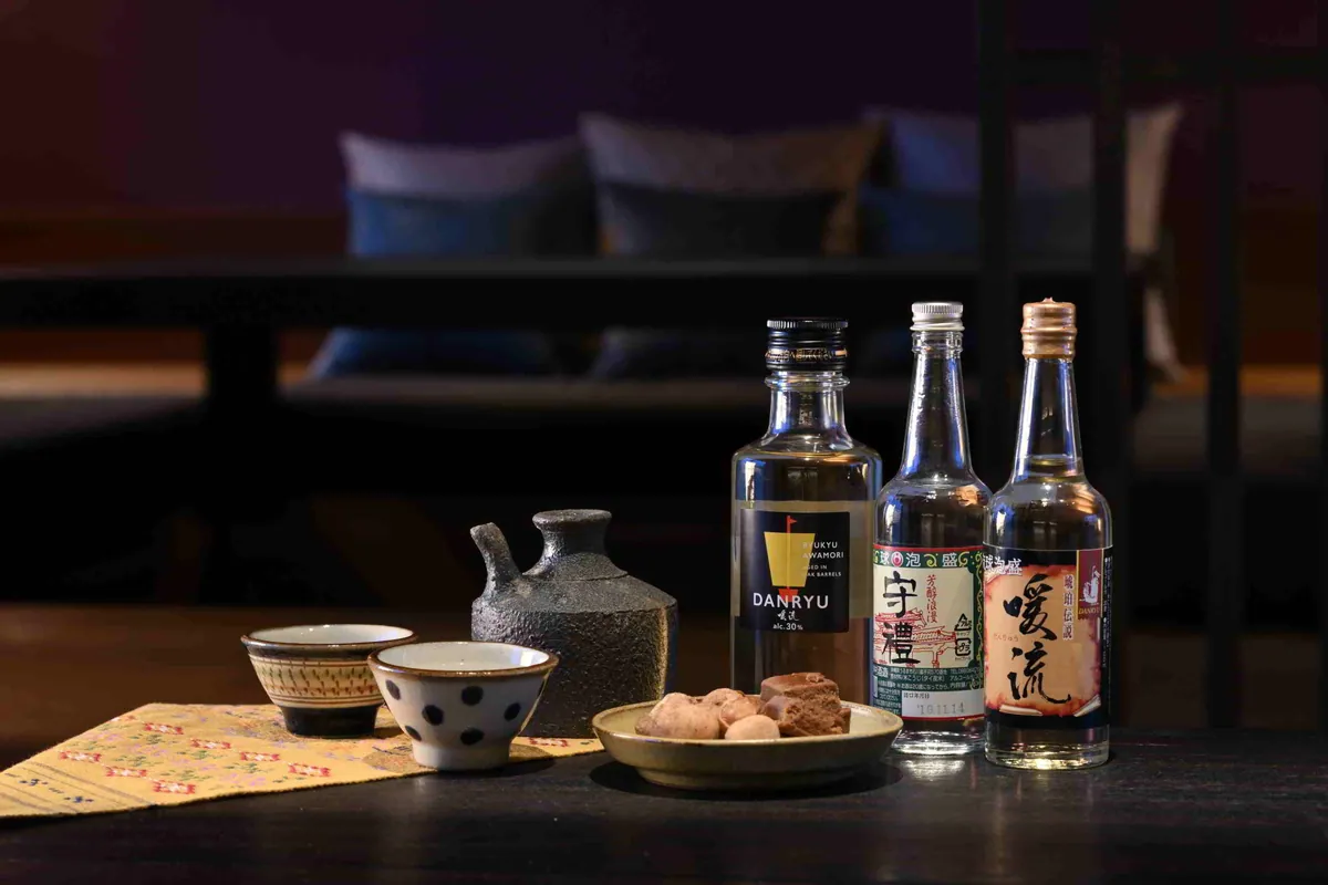 客室のテーブルに並ぶ3本の泡盛と酒器