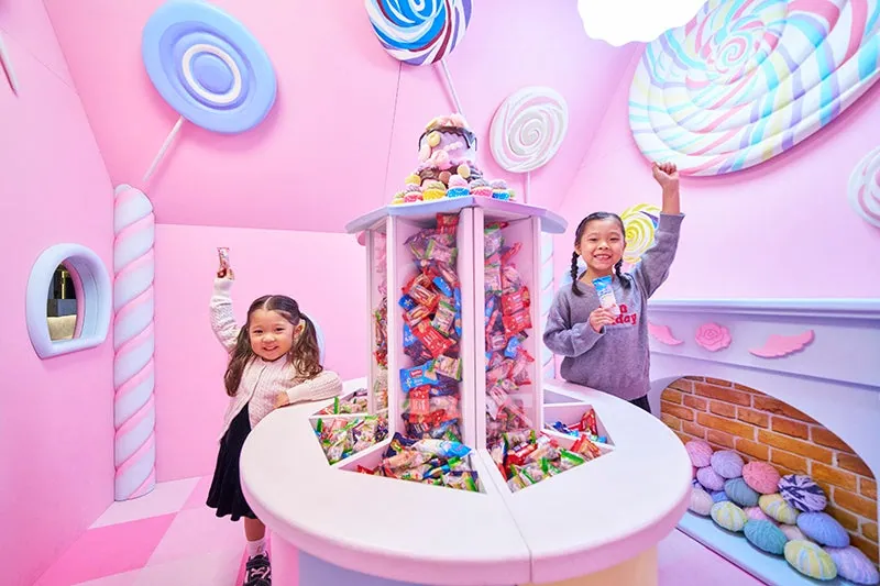 カラフルなお菓子が並ぶキャンディハウスで遊ぶ子どもたち